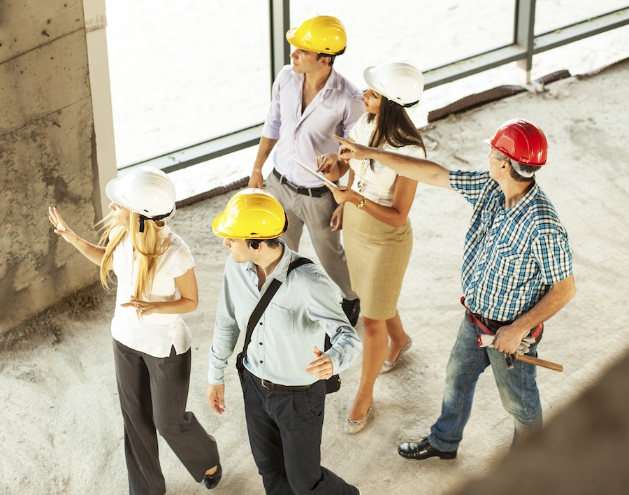 Group of architects and experts visit build site during construction.High angle view.